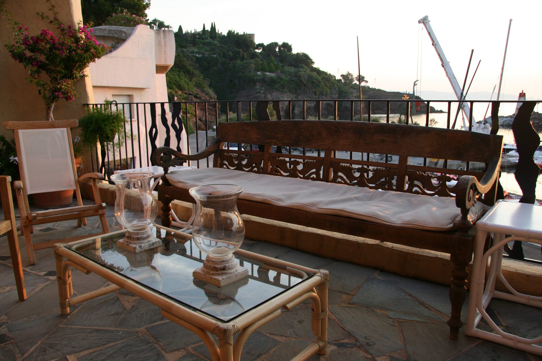 Evening on the terrace: carved bench, lanterns and the marina